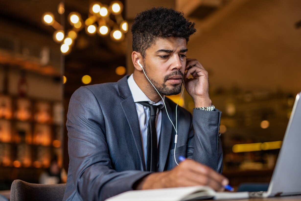 An advisor works at a computer with headphones on.