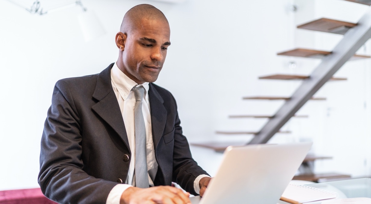 A business person works at a laptop.