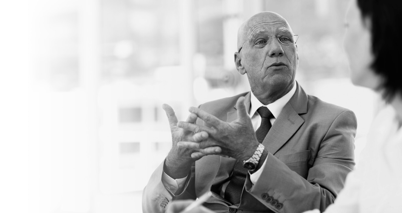 Man in a suit speaking to a woman