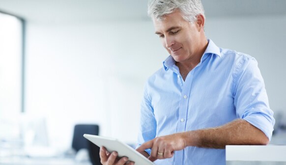 An advisor reviews the plans for his new advisory firm on a tablet.