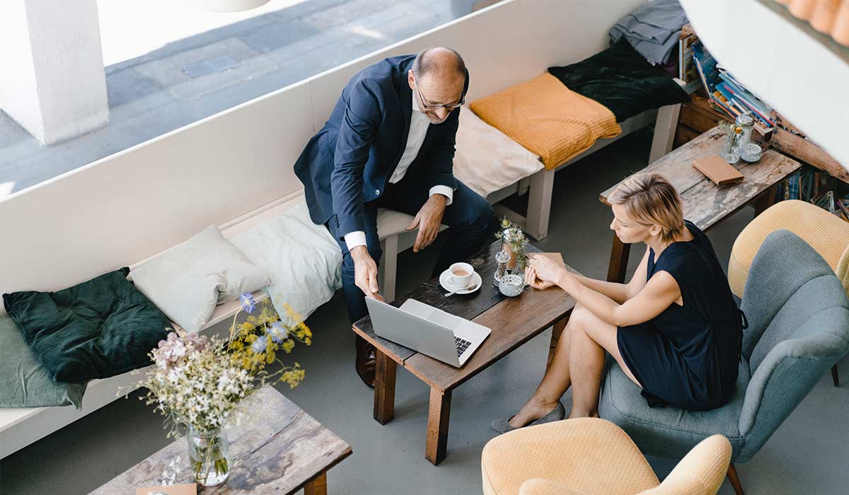 Businessman and woman having a meeting in a coffee shop, discussing work