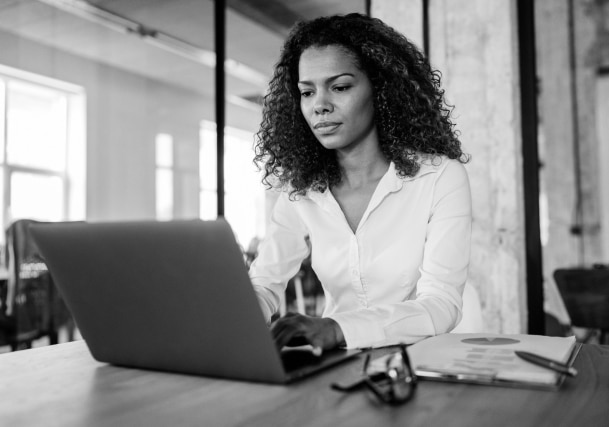 A person sits at a desk and types on a laptop.