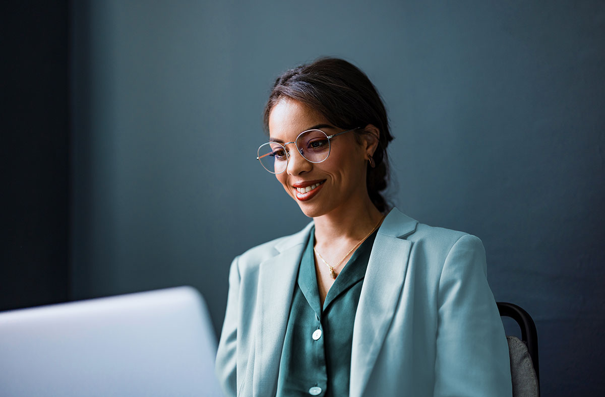 An advisor looks at a computer screen and smiles.