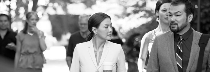 Woman holding coffee walking with man on campus