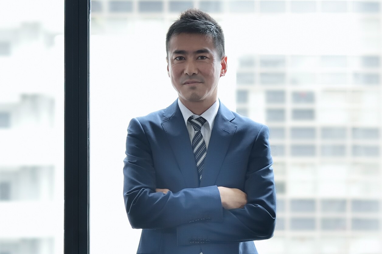 An advisor stands with their arms crossed.
