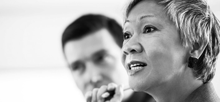Woman talking in a meeting with man in background