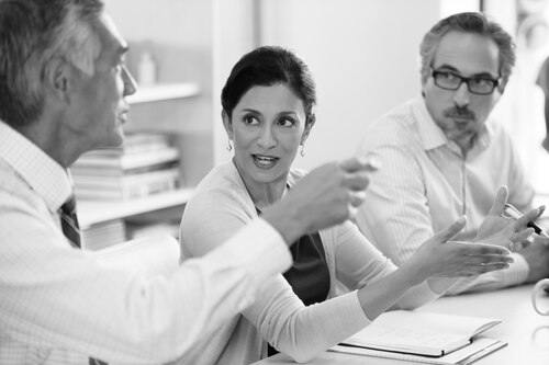 Three people in discussion at a table