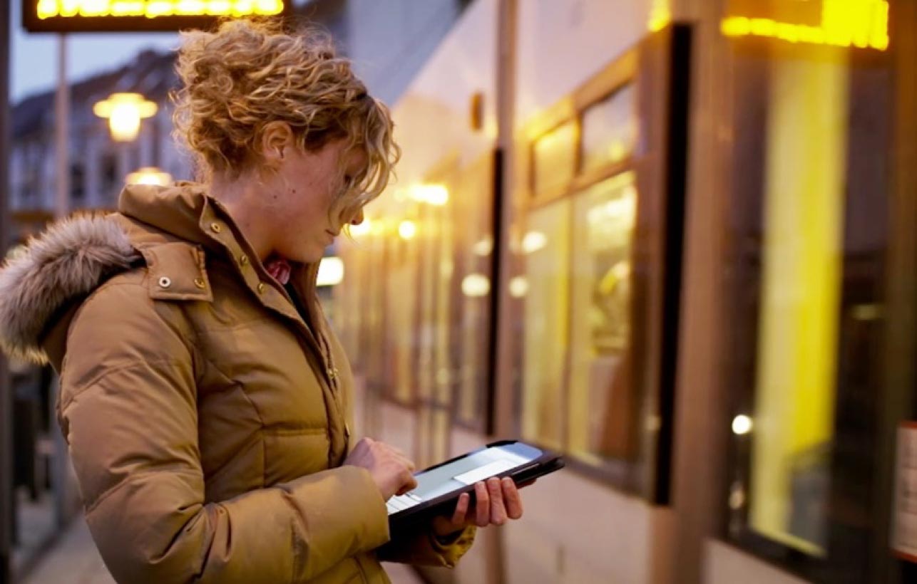 A concerned investor checks her portfolio on a tablet as she commutes.