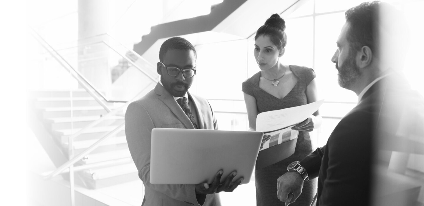 A man showing a woman something on a laptop in the office
