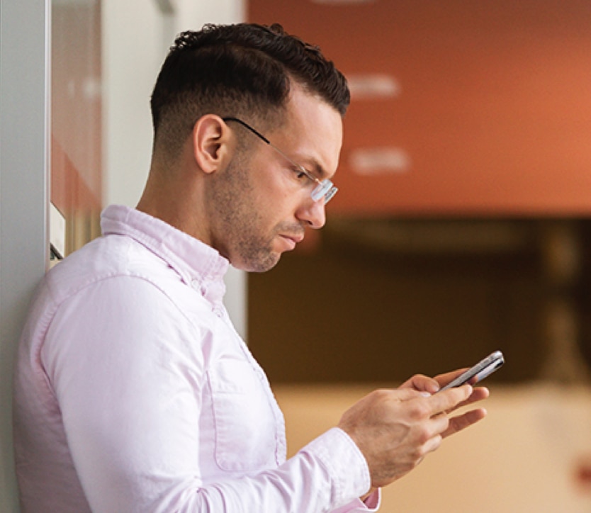 Man wearing glasses looking at phone